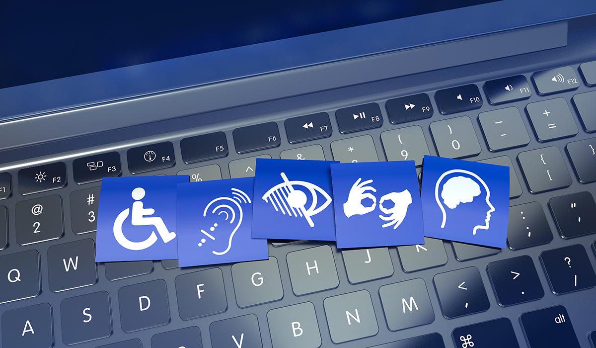 A computer keyboard with illustrations of accessibility symbols on it: a person in a wheelchair, an ear, an eye, hands forming sign language, a brain.
