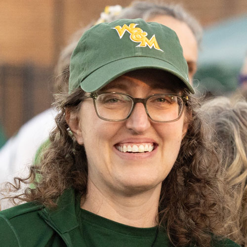 Headshot: Tiffany Broadbent Beker in a green William & Mary hat with yellow lettering.