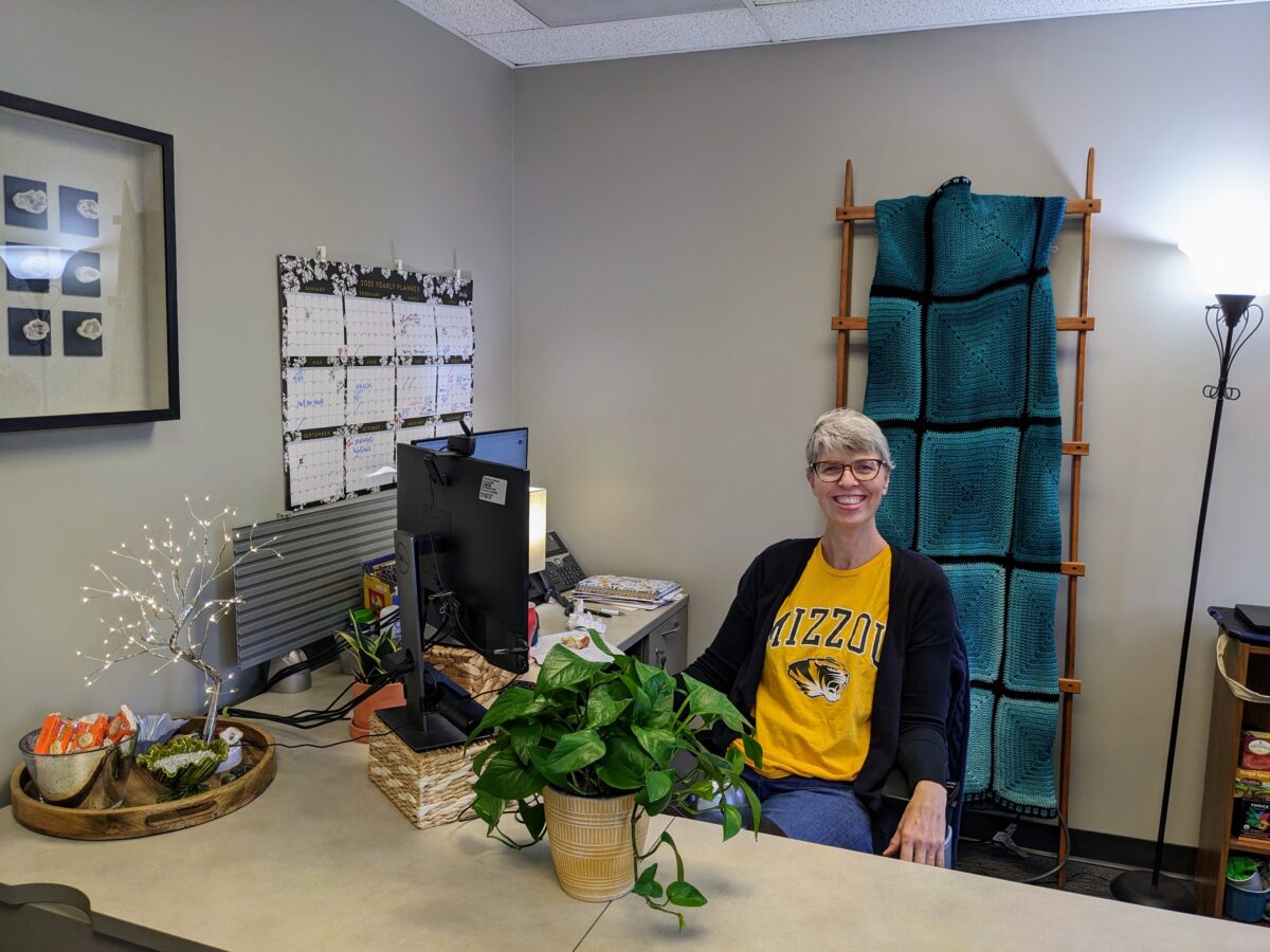 genevieve howard at her desk wearing Mizzou shirt.
