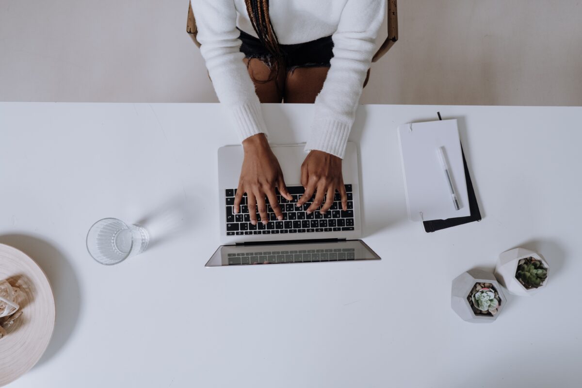 Overhead view of a person typing on a laptop while sitting at a desk